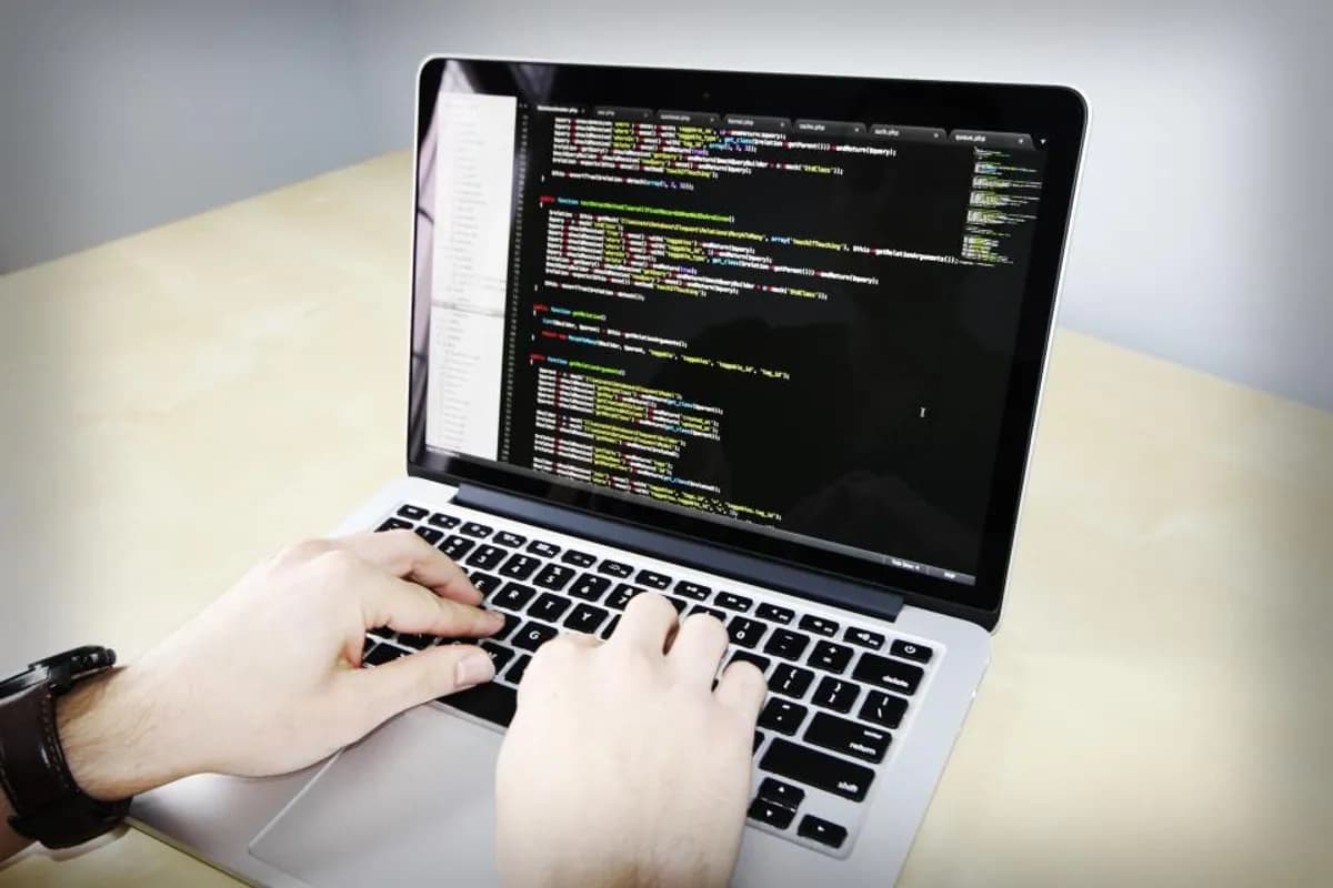 Developer writing custom software code on a laptop