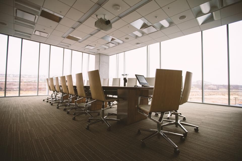 Empty modern boardroom with a long table, chairs and floor-to-ceiling windows, representing a business sales pipeline review