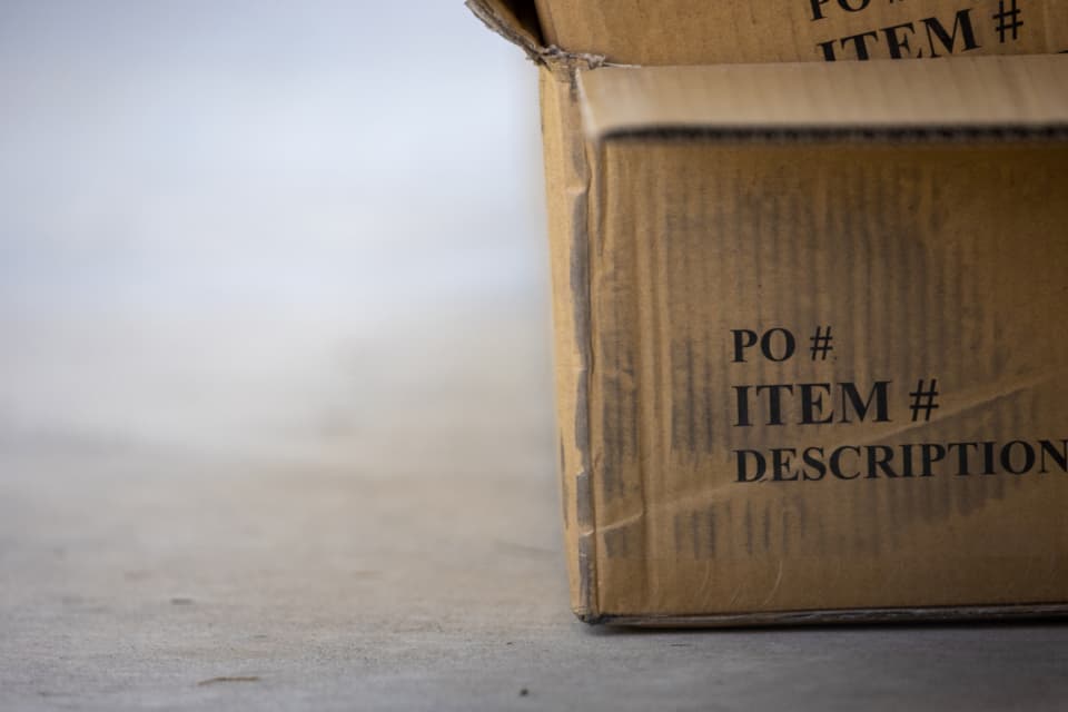 Cardboard shipping carton printed with PO number, item number and description fields